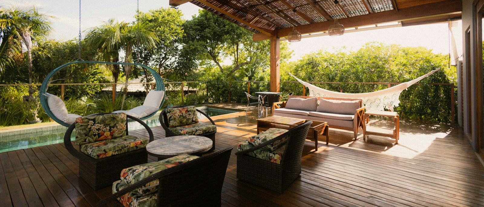 A lodge terrace with seating overlooking a pool